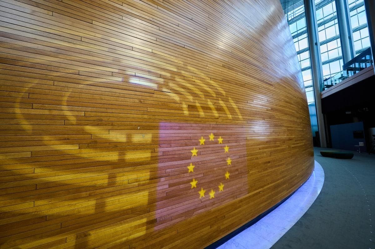 Curved wooden wall of the European Parliament with EU flag projection
